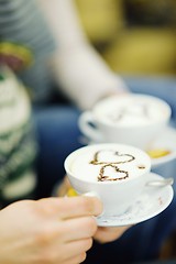 Image showing Young romantic couple sitting on sofa in front of fireplace at h