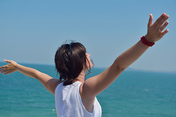 Image showing happy young woman with spreading arms to sky