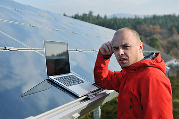 Image showing engineer using laptop at solar panels plant field