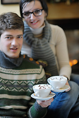 Image showing Young romantic couple sitting and relaxing in front of fireplace