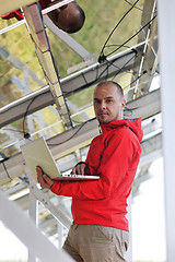 Image showing engineer using laptop at solar panels plant field