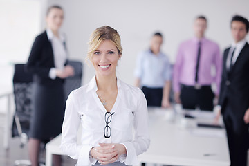 Image showing business woman standing with her staff in background