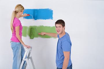 Image showing happy couple paint wall at new home