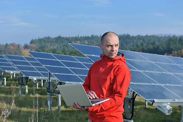 Image showing engineer using laptop at solar panels plant field