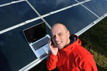 Image showing engineer using laptop at solar panels plant field