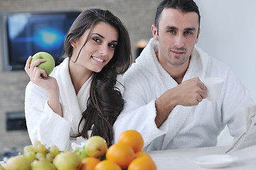 Image showing Happy couple reading the newspaper in the kitchen at breakfast