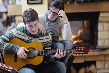 Image showing Young romantic couple sitting and relaxing in front of fireplace