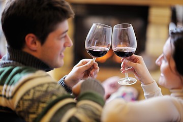 Image showing Young romantic couple relax on sofa in front of fireplace at hom