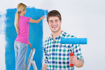 Image showing happy couple paint wall at new home