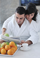 Image showing Happy couple reading the newspaper in the kitchen at breakfast