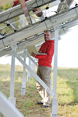 Image showing engineer using laptop at solar panels plant field