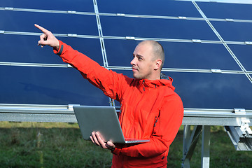 Image showing engineer using laptop at solar panels plant field