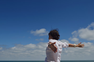 Image showing happy young woman with spreading arms to sky