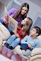 Image showing young mom play with their kids at home and reading book