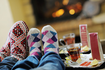 Image showing Young romantic couple sitting and relaxing in front of fireplace