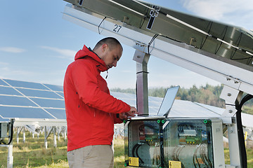 Image showing engineer using laptop at solar panels plant field