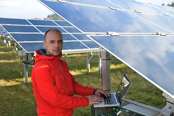 Image showing engineer using laptop at solar panels plant field