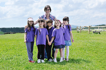 Image showing happy kids group with teacher in nature