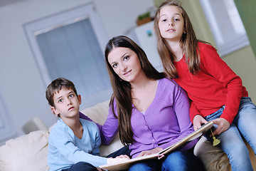 Image showing young mom play with their kids at home and reading book