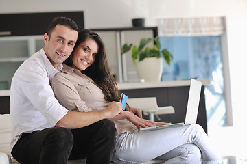 Image showing joyful couple relax and work on laptop computer at modern home