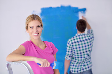 Image showing happy couple paint wall at new home