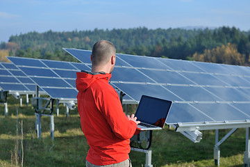 Image showing engineer using laptop at solar panels plant field