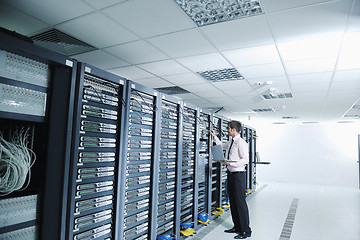 Image showing businessman with laptop in network server room