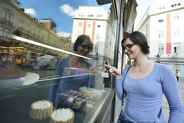 Image showing woman in front of sweet store window