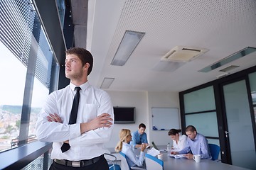 Image showing business man  on a meeting in offce with colleagues in backgroun