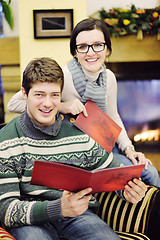 Image showing Young romantic couple sitting and relaxing in front of fireplace