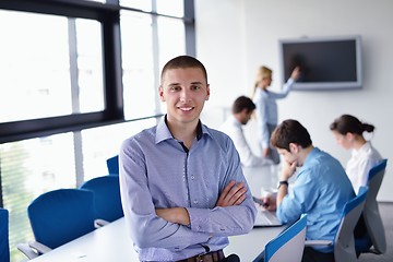 Image showing business man  on a meeting in offce with colleagues in backgroun