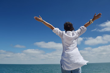 Image showing happy young woman with spreading arms to sky