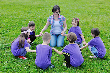 Image showing happy kids group with teacher in nature