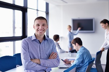 Image showing business man  on a meeting in offce with colleagues in backgroun