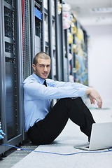 Image showing businessman with laptop in network server room