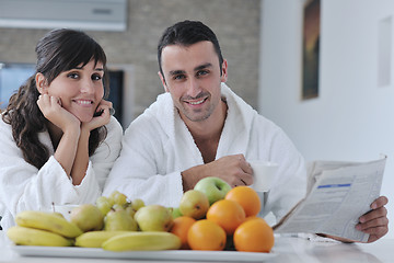 Image showing Happy couple reading the newspaper in the kitchen at breakfast