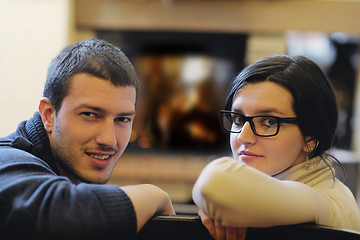 Image showing Young romantic couple sitting and relaxing in front of fireplace