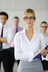 Image showing business woman standing with her staff in background