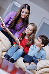 Image showing young mom play with their kids at home and reading book