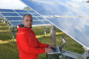 Image showing engineer using laptop at solar panels plant field