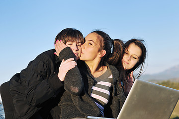 Image showing group of teens working on laptop outdoor