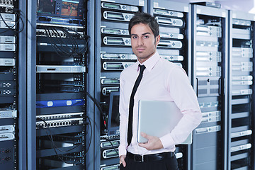 Image showing businessman with laptop in network server room