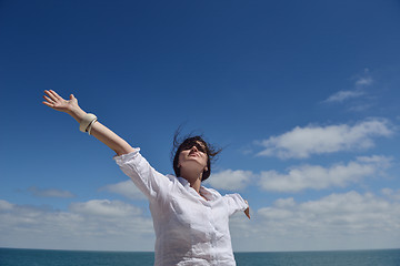 Image showing happy young woman with spreading arms to sky