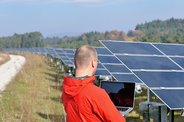 Image showing engineer using laptop at solar panels plant field