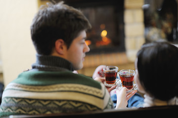 Image showing Young romantic couple sitting and relaxing in front of fireplace