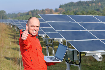 Image showing engineer using laptop at solar panels plant field