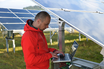 Image showing engineer using laptop at solar panels plant field