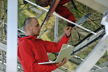 Image showing engineer using laptop at solar panels plant field