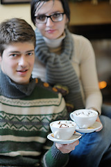 Image showing Young romantic couple sitting and relaxing in front of fireplace