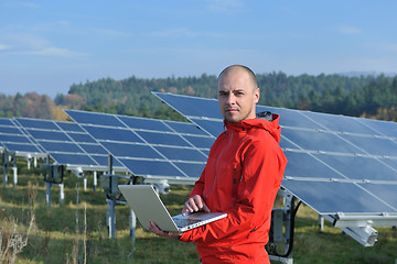 Image showing engineer using laptop at solar panels plant field